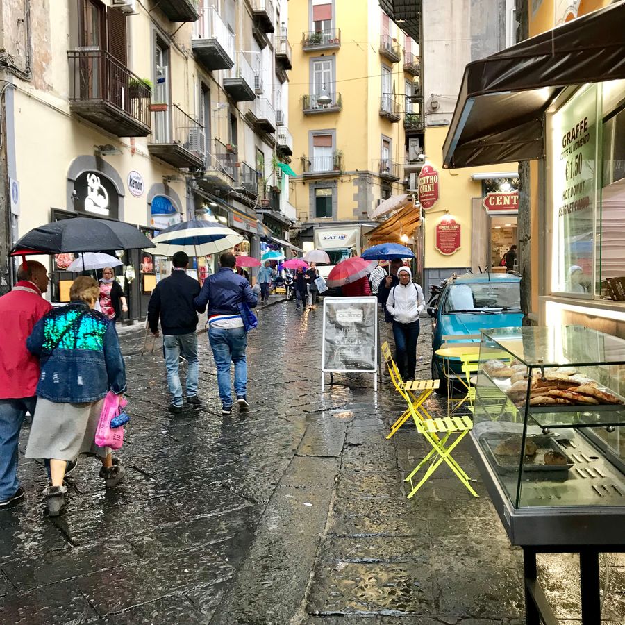 regenachtige dag in napels met toeristen met paraplu's
